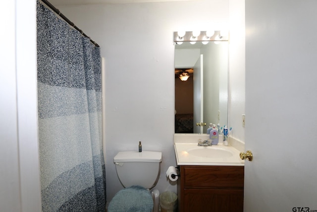 full bathroom featuring curtained shower, vanity, and toilet