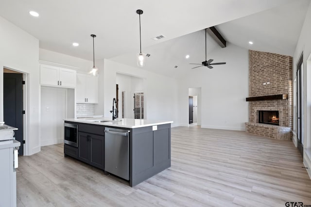 kitchen featuring white cabinets, light hardwood / wood-style flooring, a kitchen island with sink, and stainless steel appliances