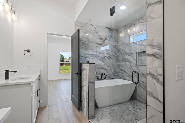 bathroom with vanity, hardwood / wood-style flooring, tile walls, and independent shower and bath