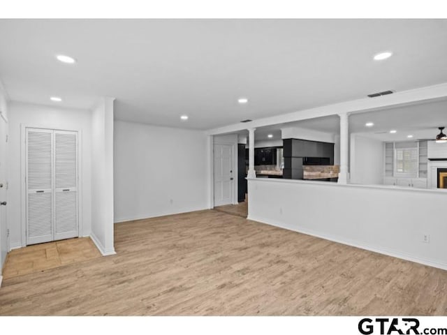 unfurnished living room featuring a fireplace, recessed lighting, wood finished floors, and baseboards