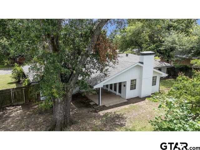 1812 Montrose Dr, Tyler, TX 75701 - rear view of house featuring a patio, a chimney, and roof with shingles