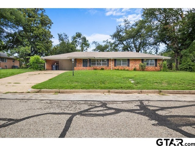 ranch-style house featuring concrete driveway, a carport, a front yard, and brick siding