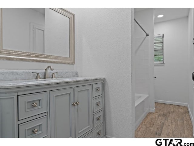 1812 Montrose Dr, Tyler, TX 75701 - bathroom with vanity, wood finished floors, tub / shower combination, and baseboards