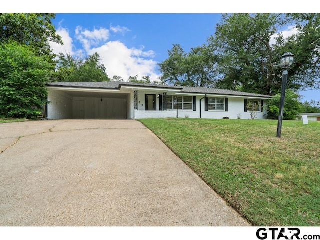 1812 Montrose Dr, Tyler, TX 75701 - ranch-style house with driveway, an attached carport, and a front lawn