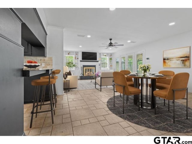 1812 Montrose Dr, Tyler, TX 75701 - dining area featuring a glass covered fireplace, ceiling fan, and recessed lighting