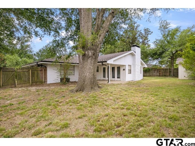 back of property with a chimney and french doors