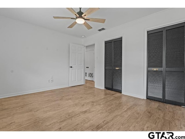 1812 Montrose Dr, Tyler, TX 75701 - unfurnished bedroom with multiple closets, light wood-style flooring, baseboards, ornamental molding, and a ceiling fan