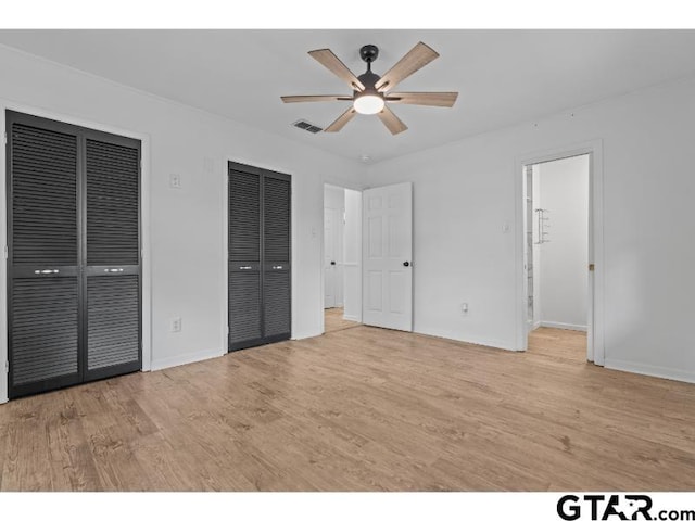 1812 Montrose Dr, Tyler, TX 75701 - unfurnished bedroom with two closets, light wood finished floors, baseboards, and a ceiling fan