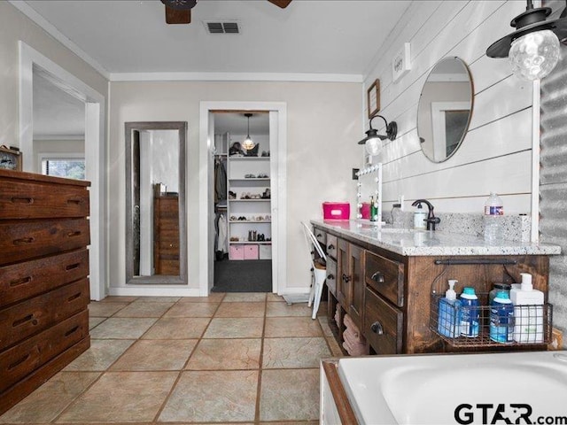 bathroom with ornamental molding, a washtub, vanity, and ceiling fan