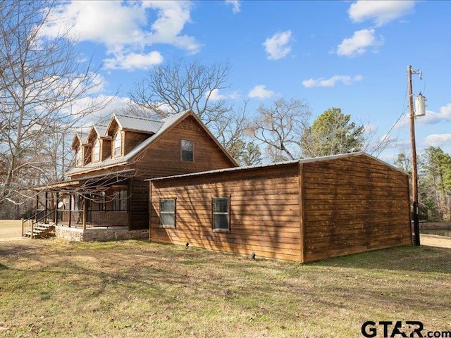 view of side of property with a yard and covered porch