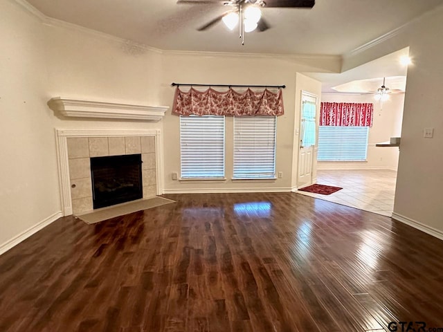 unfurnished living room featuring a fireplace, hardwood / wood-style flooring, ceiling fan, and ornamental molding