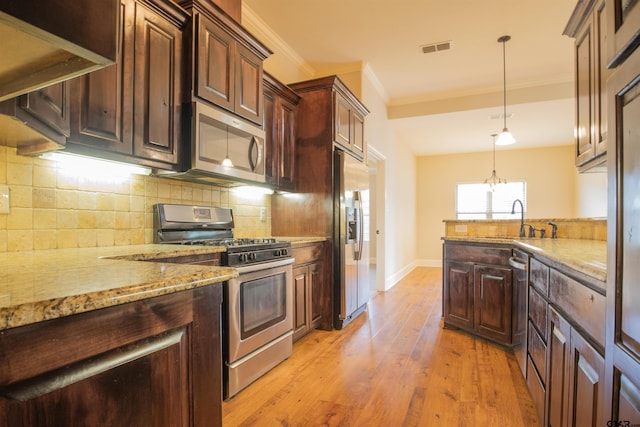 kitchen with sink, stainless steel appliances, backsplash, light wood-type flooring, and ornamental molding