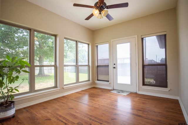 unfurnished sunroom with ceiling fan and plenty of natural light