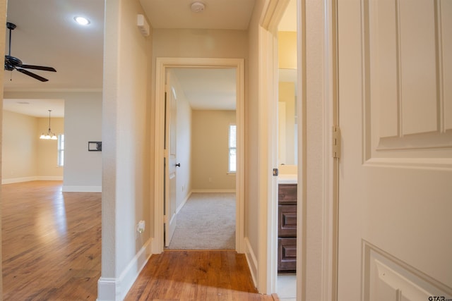 hall with a notable chandelier and light wood-type flooring