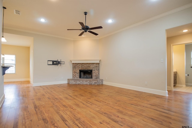 unfurnished living room with ceiling fan, light wood-type flooring, a fireplace, and ornamental molding