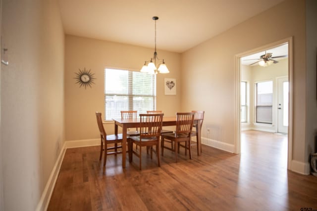 dining area featuring dark hardwood / wood-style floors and ceiling fan with notable chandelier