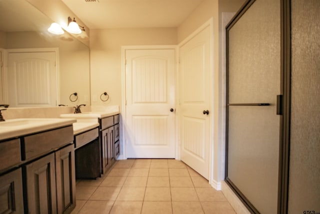 bathroom featuring tile patterned flooring, vanity, and a shower with shower door