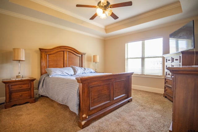 carpeted bedroom featuring ceiling fan, crown molding, and a tray ceiling