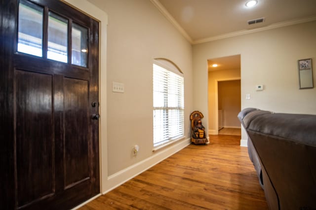 foyer with light wood-type flooring and crown molding