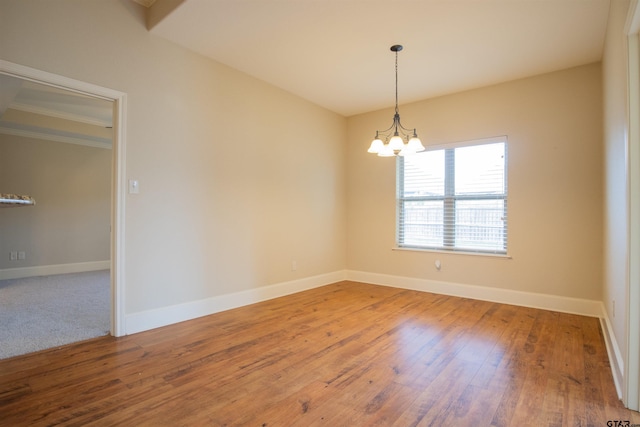 unfurnished room with a notable chandelier and hardwood / wood-style flooring