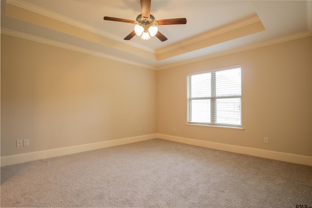 unfurnished room with a raised ceiling, crown molding, carpet, and ceiling fan