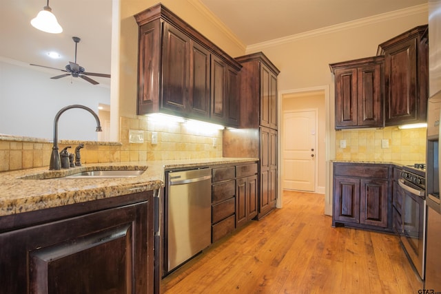 kitchen with appliances with stainless steel finishes, light wood-type flooring, light stone counters, ceiling fan, and sink