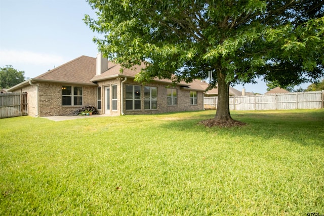 rear view of property featuring a lawn