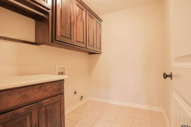 laundry room with electric dryer hookup, light tile patterned floors, cabinets, and washer hookup