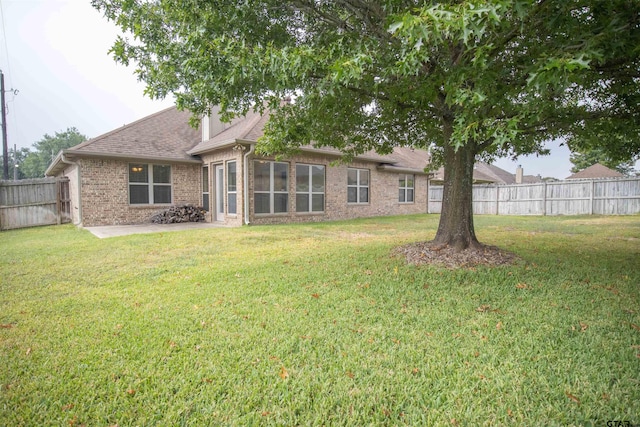 rear view of property featuring a yard and a patio