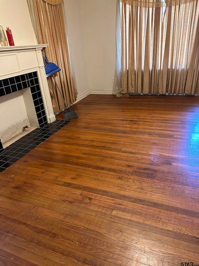 unfurnished living room with a tile fireplace and dark hardwood / wood-style flooring