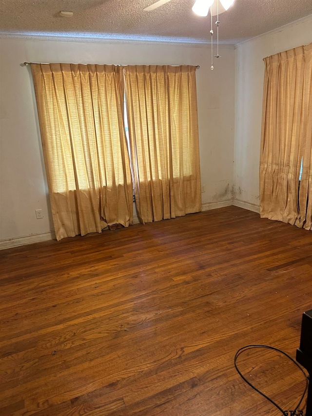 spare room with ceiling fan, a textured ceiling, and dark hardwood / wood-style flooring