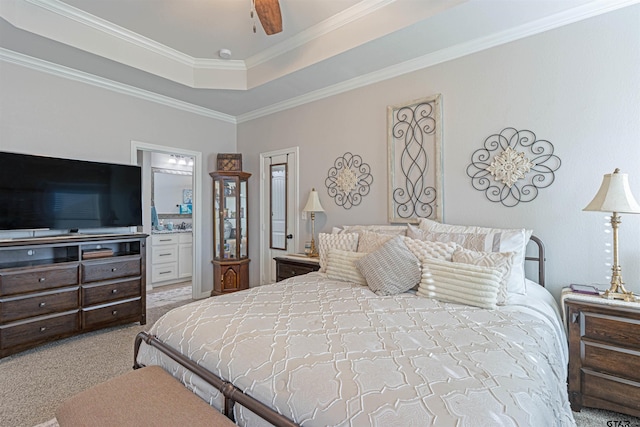 carpeted bedroom featuring crown molding, a raised ceiling, ceiling fan, and ensuite bathroom