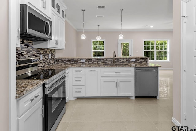 kitchen with a sink, stainless steel appliances, a peninsula, crown molding, and decorative backsplash