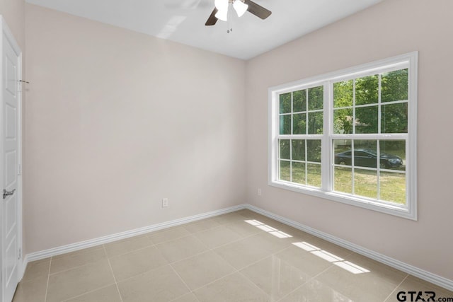 spare room with baseboards and a healthy amount of sunlight