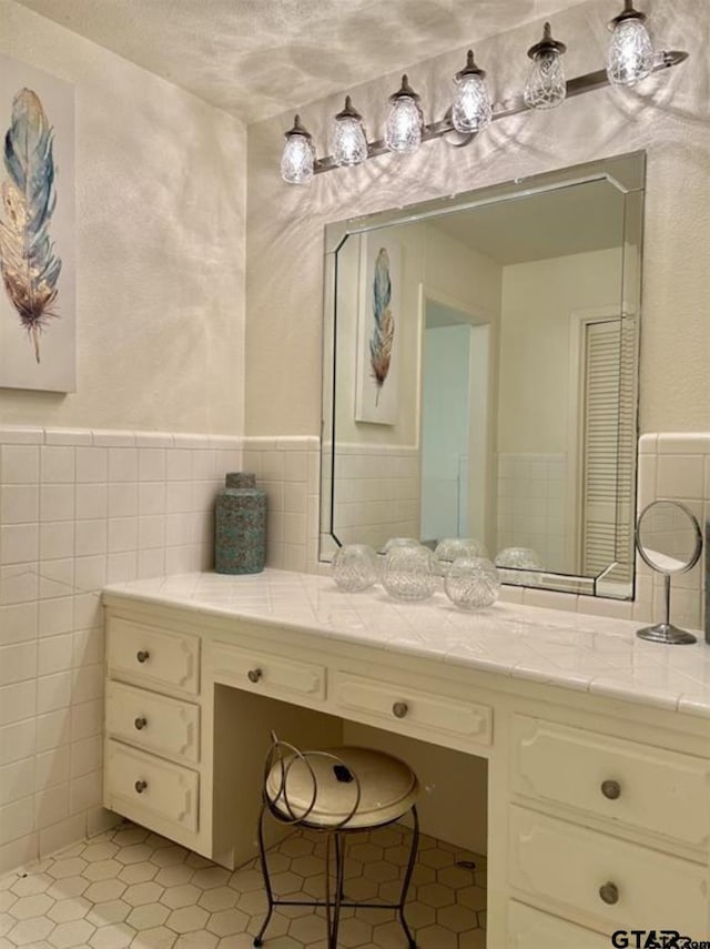 114 Mockingbird, Mount Pleasant, TX 75455 - bathroom with tile walls, tile patterned floors, vanity, and a wainscoted wall