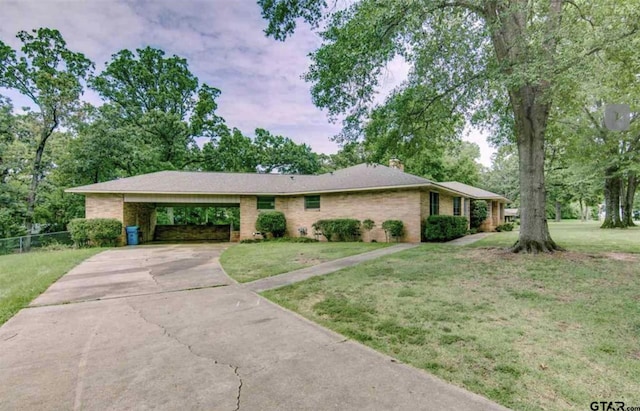 114 Mockingbird, Mount Pleasant, TX 75455 - ranch-style house featuring a chimney, concrete driveway, an attached carport, and brick siding