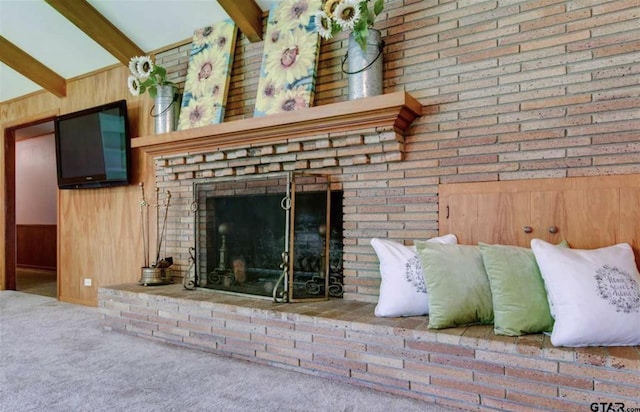 114 Mockingbird, Mount Pleasant, TX 75455 - detailed view of carpet, beam ceiling, wooden walls, and a brick fireplace