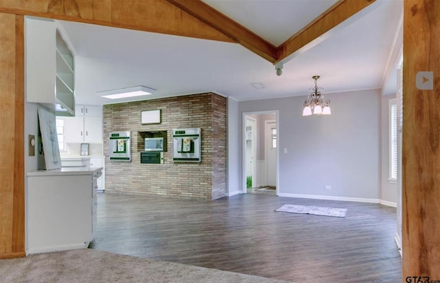 114 Mockingbird, Mount Pleasant, TX 75455 - unfurnished living room with a chandelier, wood finished floors, brick wall, healthy amount of natural light, and baseboards