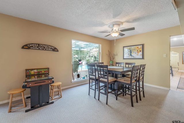 carpeted dining room with a textured ceiling and ceiling fan