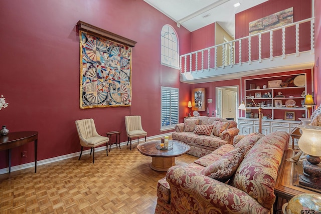 living room featuring a high ceiling, track lighting, and light parquet floors