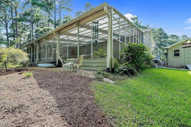 back of property with a lawn and an outbuilding