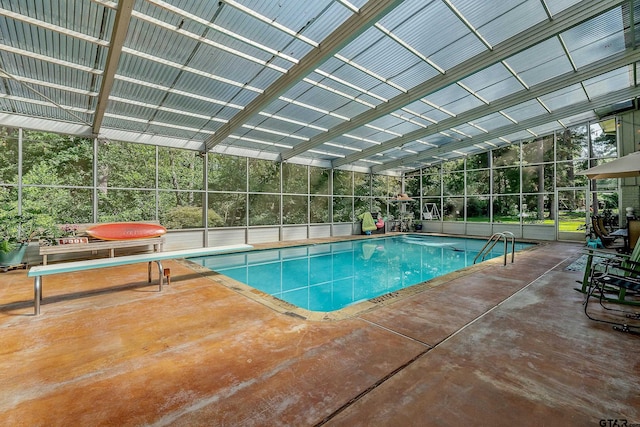 view of pool with glass enclosure and a patio area