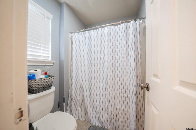 bathroom with a shower with shower curtain and toilet