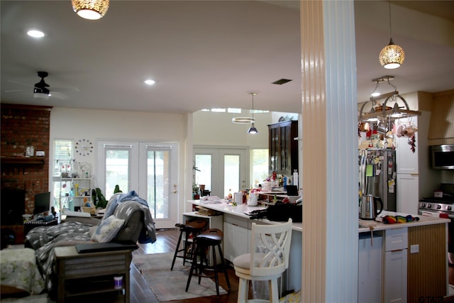 kitchen featuring hanging light fixtures, wood-type flooring, appliances with stainless steel finishes, and french doors