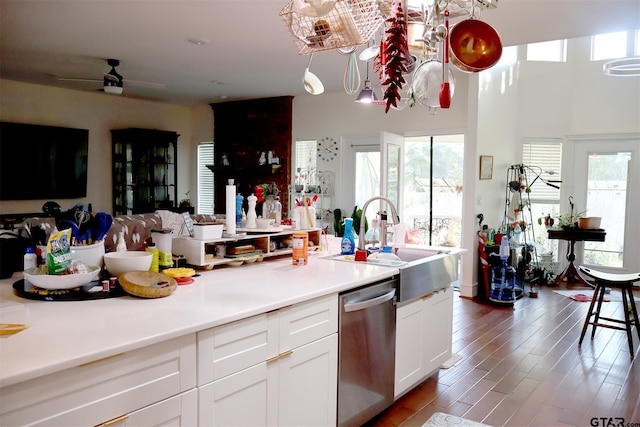 kitchen featuring pendant lighting, dishwasher, sink, white cabinets, and hardwood / wood-style flooring