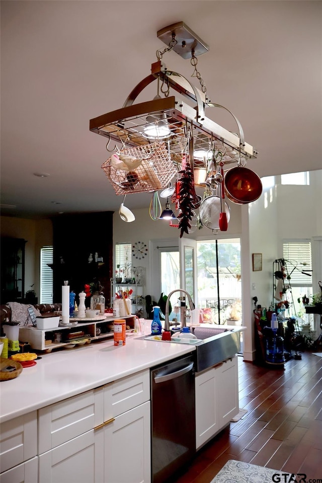 kitchen with stainless steel dishwasher, dark hardwood / wood-style floors, sink, and white cabinets