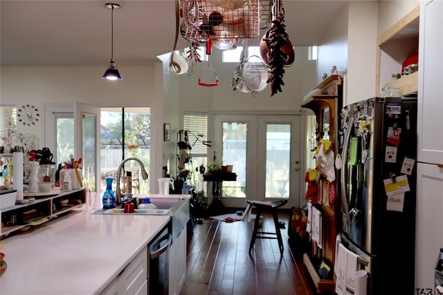 kitchen with plenty of natural light, decorative light fixtures, white cabinets, and black appliances