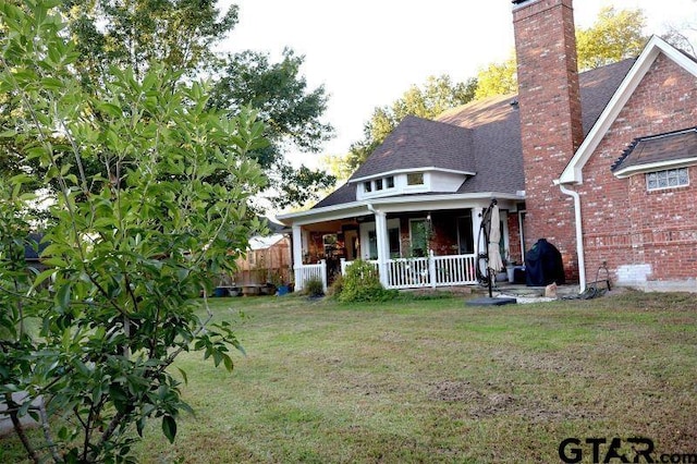 back of property featuring a porch and a yard