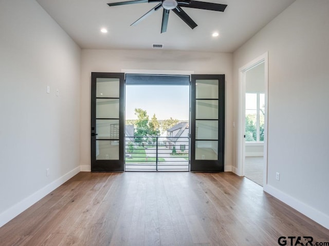 unfurnished room featuring light hardwood / wood-style flooring, ceiling fan, and plenty of natural light