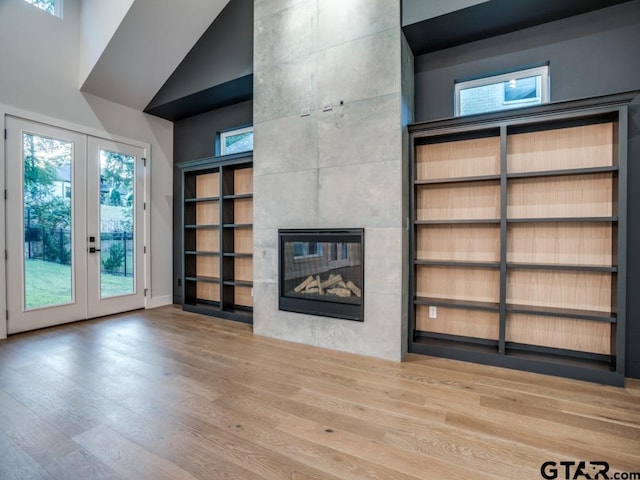 2424 Bellview Cir, Tyler, TX 75709 - unfurnished living room with french doors, a fireplace, wood finished floors, and a high ceiling